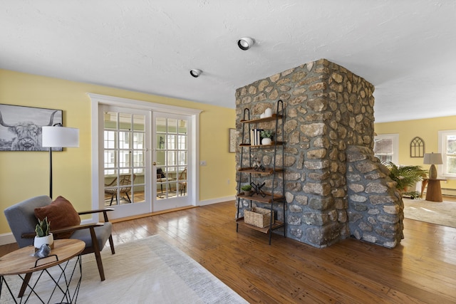 living area with hardwood / wood-style flooring and french doors