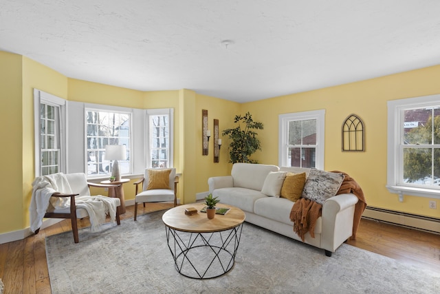 living room with light wood-type flooring, a baseboard radiator, and plenty of natural light