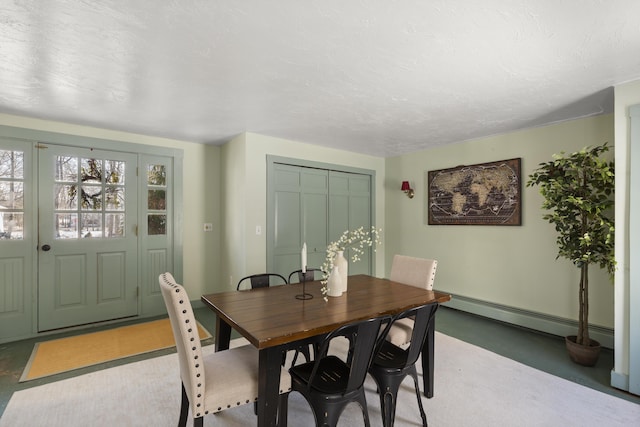 dining area with a textured ceiling and a baseboard heating unit