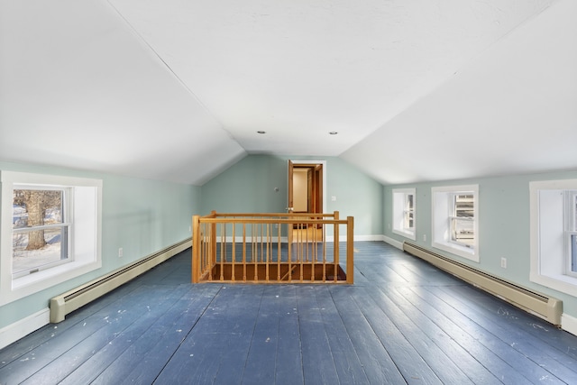 additional living space with dark hardwood / wood-style flooring, a baseboard heating unit, and vaulted ceiling