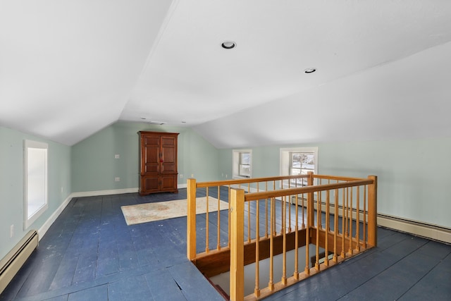 additional living space featuring a baseboard radiator, lofted ceiling, and dark hardwood / wood-style floors