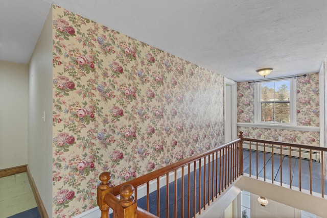 interior space with a textured ceiling and baseboard heating