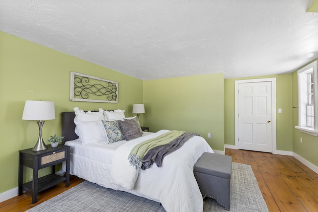 bedroom featuring hardwood / wood-style flooring and a textured ceiling