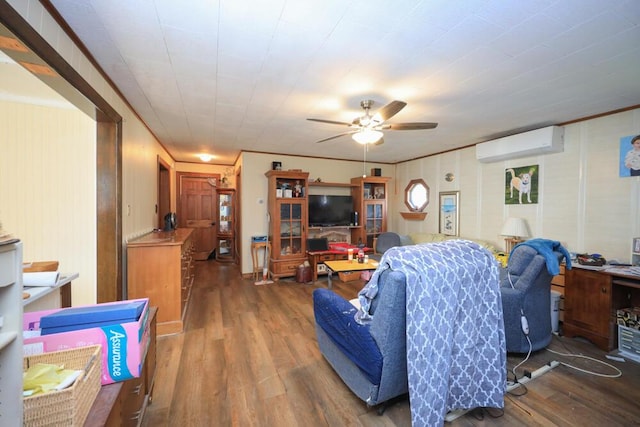 living area with a ceiling fan, an AC wall unit, and wood finished floors