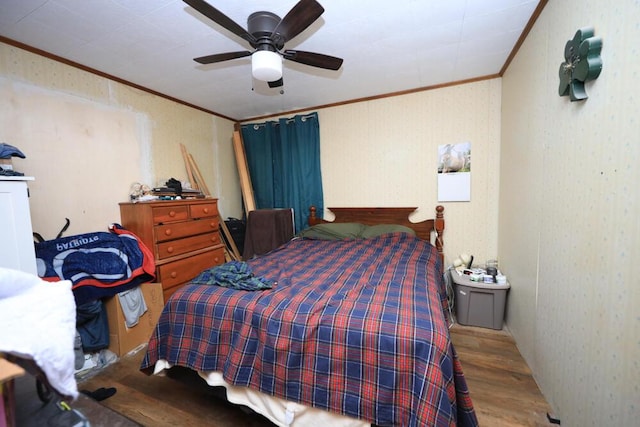 bedroom with wallpapered walls, ceiling fan, ornamental molding, and wood finished floors