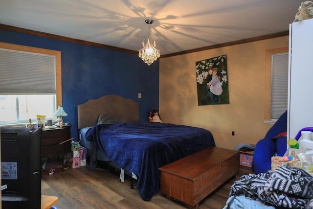 bedroom with ornamental molding, a notable chandelier, and wood finished floors