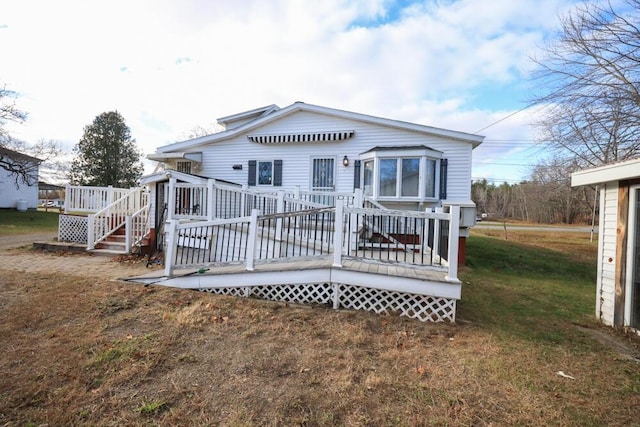 bungalow-style house with a deck and a front lawn