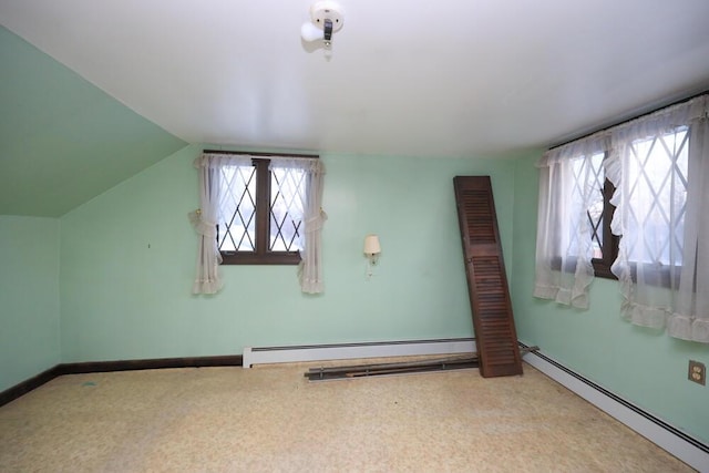 interior space with vaulted ceiling, baseboards, baseboard heating, and carpet flooring