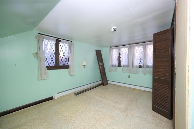 spare room with lofted ceiling, a baseboard radiator, and baseboards