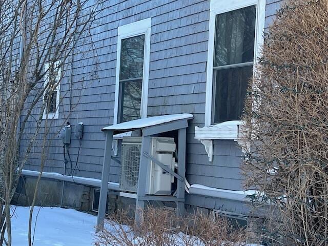 view of snowy exterior with ac unit