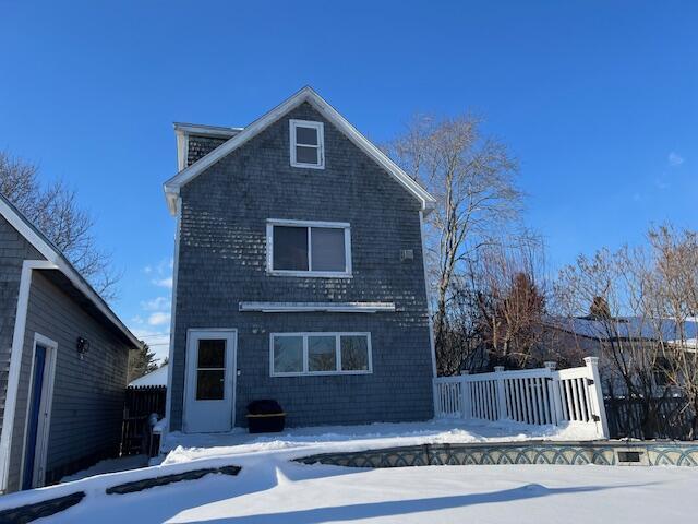 view of snow covered rear of property