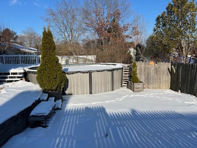 yard covered in snow with a fenced in pool