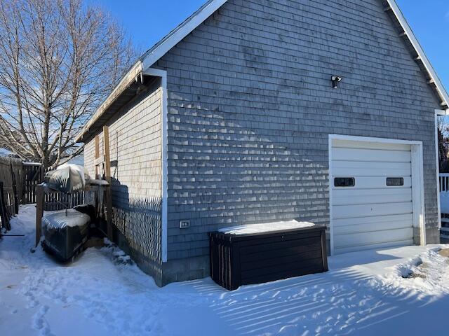 view of snow covered exterior featuring a garage