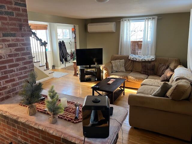 living room with hardwood / wood-style flooring and a wall mounted AC