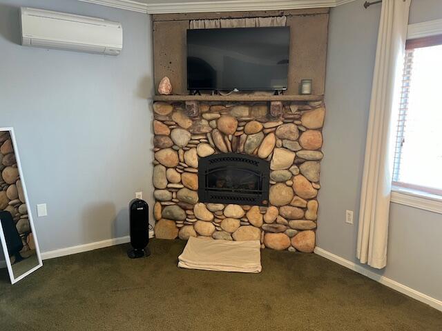 interior details with a stone fireplace, ornamental molding, an AC wall unit, and carpet flooring