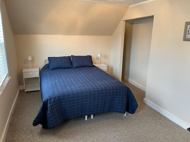 carpeted bedroom with vaulted ceiling