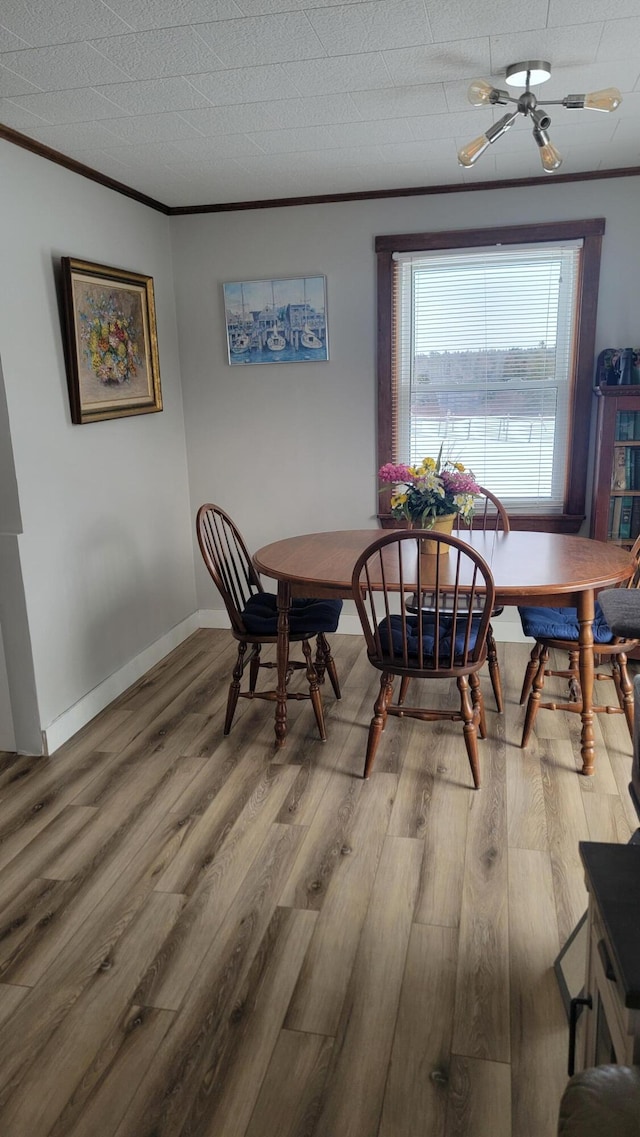 dining space featuring ornamental molding, a water view, and hardwood / wood-style floors