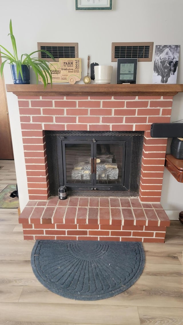 room details with hardwood / wood-style flooring and a brick fireplace