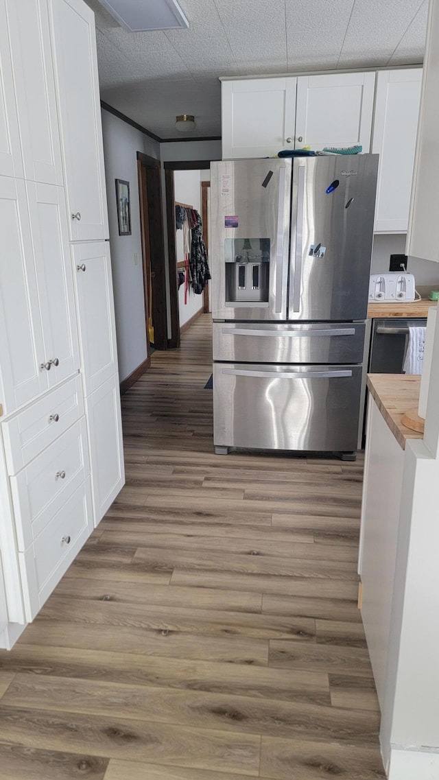 kitchen featuring white cabinetry, hardwood / wood-style flooring, wooden counters, and stainless steel refrigerator with ice dispenser