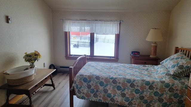 bedroom featuring light hardwood / wood-style flooring and baseboard heating