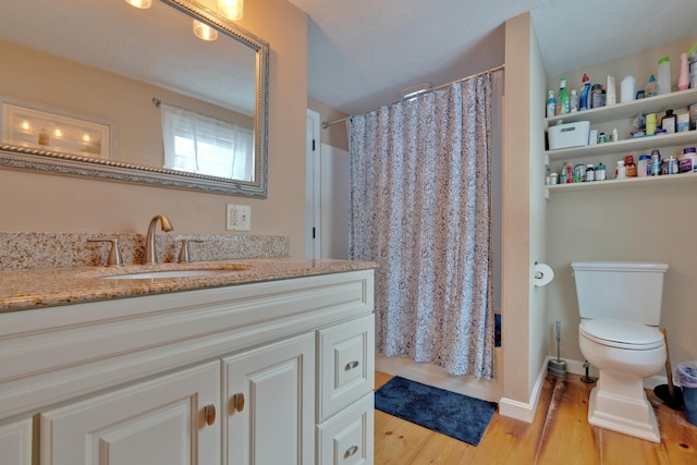 bathroom featuring vanity, hardwood / wood-style floors, a textured ceiling, and walk in shower