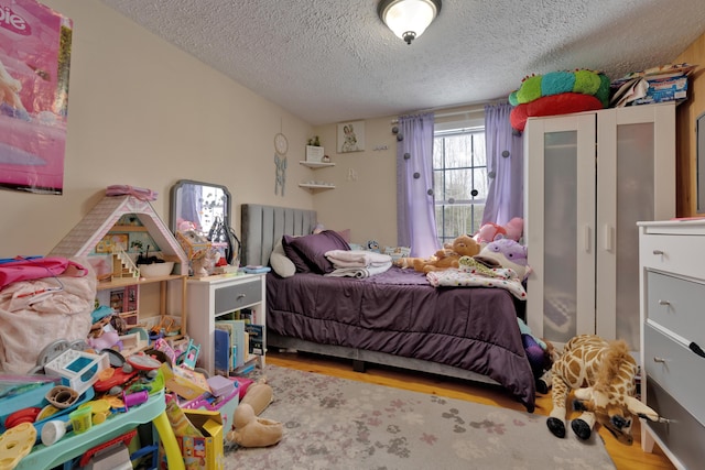 bedroom featuring hardwood / wood-style flooring and a textured ceiling