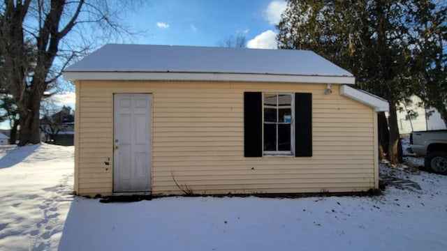 snow covered structure featuring an outbuilding