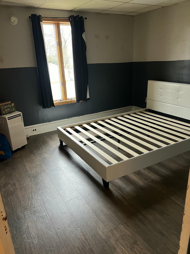 bedroom featuring dark wood-style flooring and a paneled ceiling