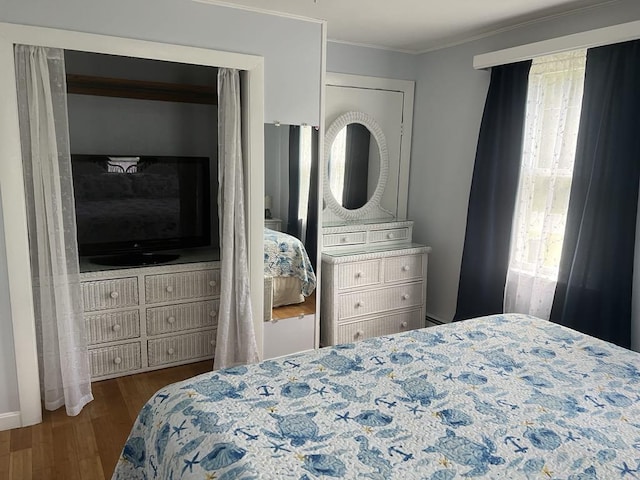 bedroom with multiple windows, ornamental molding, and dark hardwood / wood-style floors