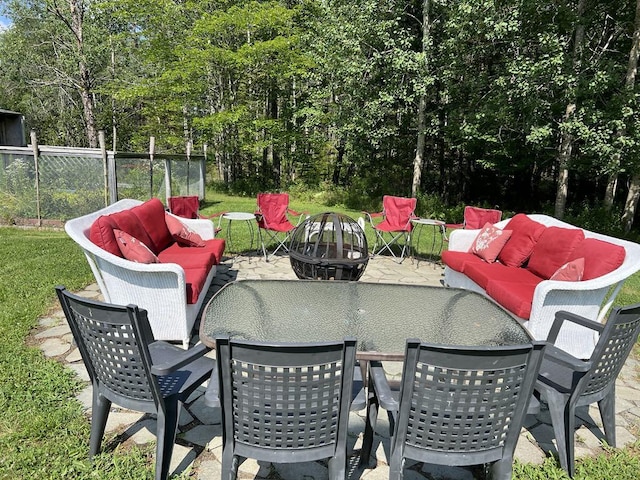 view of patio with an outdoor living space with a fire pit