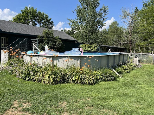 view of swimming pool with a lawn