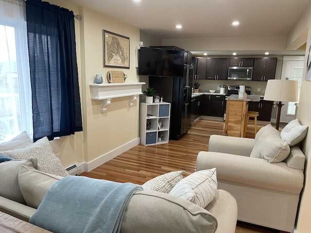 living room featuring light wood-type flooring and a baseboard radiator