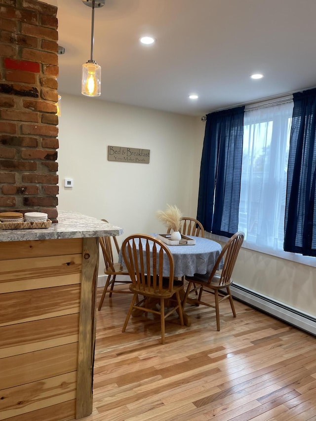 dining space featuring light wood-type flooring and a baseboard radiator