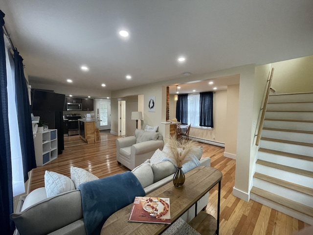 living room featuring baseboard heating and light hardwood / wood-style floors