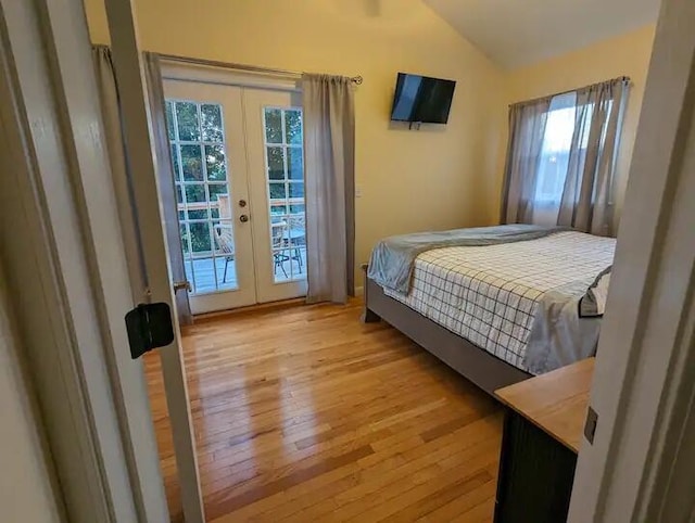 bedroom featuring access to outside, multiple windows, vaulted ceiling, and french doors