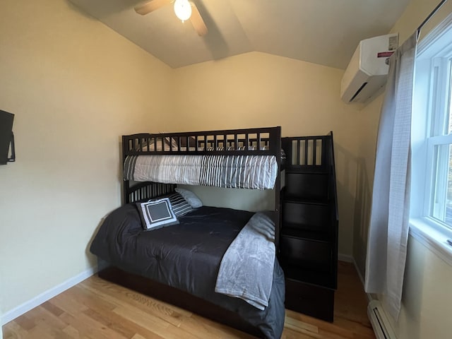 bedroom featuring light hardwood / wood-style floors, a baseboard radiator, a wall unit AC, ceiling fan, and lofted ceiling