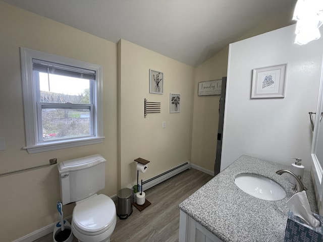 bathroom featuring a baseboard radiator, wood-type flooring, vanity, toilet, and vaulted ceiling