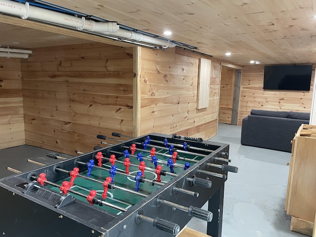 playroom featuring wooden walls, concrete flooring, and wood ceiling