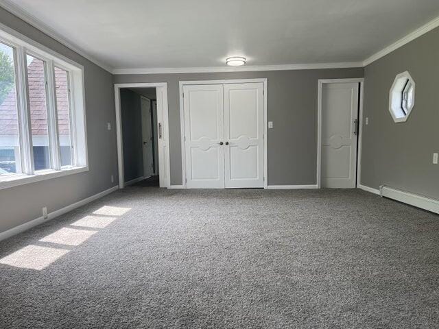 unfurnished bedroom with multiple closets, ornamental molding, multiple windows, and carpet flooring