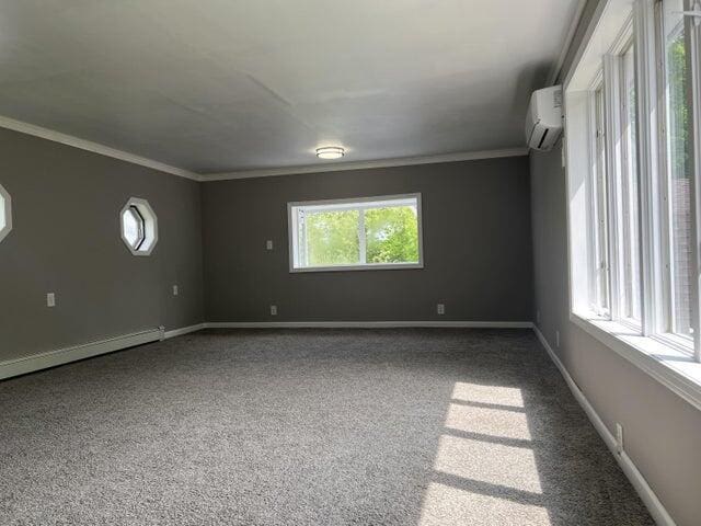 carpeted spare room with an AC wall unit, ornamental molding, and a baseboard radiator