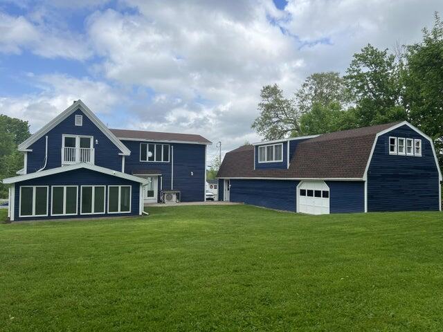 back of house with an outbuilding and a lawn