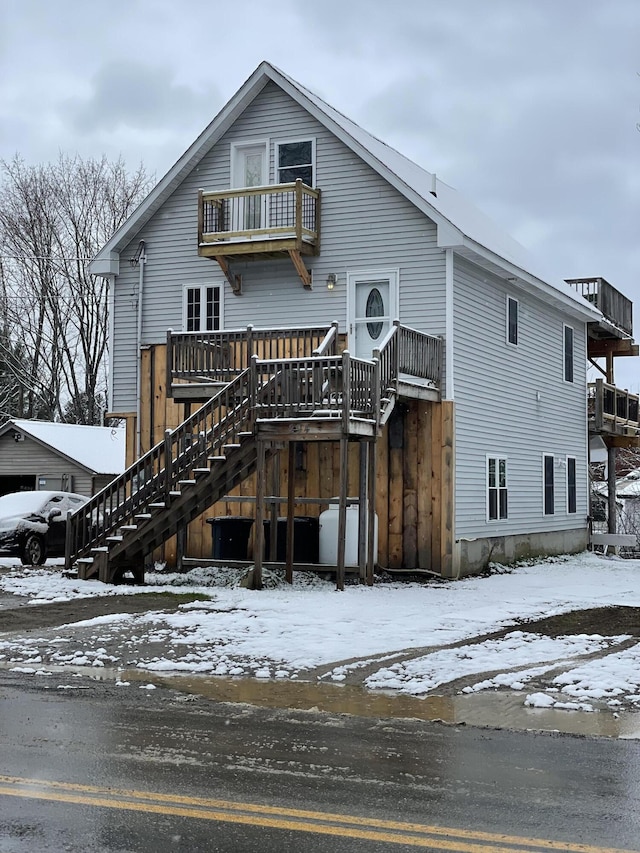 snow covered house with a balcony and a deck