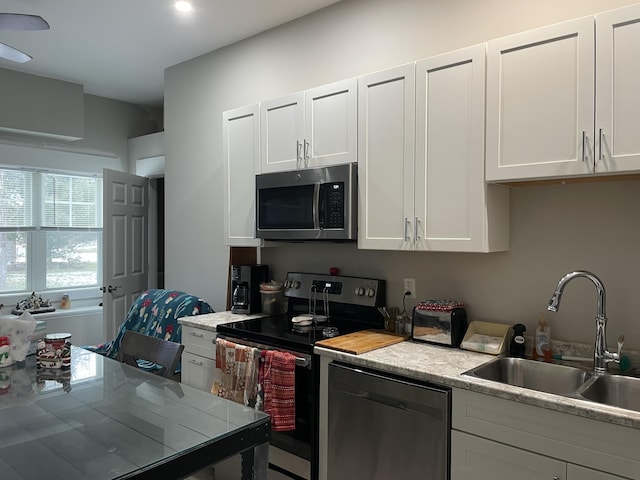 kitchen with sink, stainless steel appliances, and white cabinetry