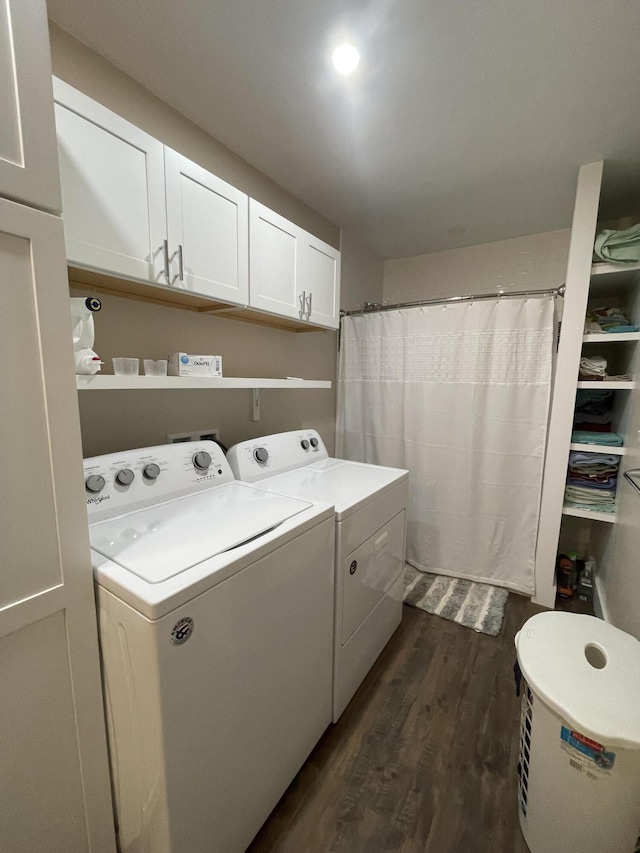 clothes washing area featuring washing machine and clothes dryer, dark hardwood / wood-style floors, and cabinets