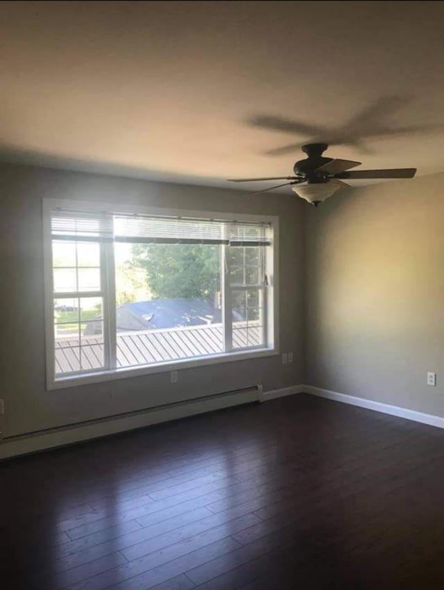 unfurnished room featuring ceiling fan, a baseboard heating unit, and dark hardwood / wood-style flooring