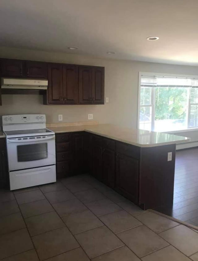 kitchen featuring a baseboard heating unit, electric stove, kitchen peninsula, light tile patterned floors, and dark brown cabinets