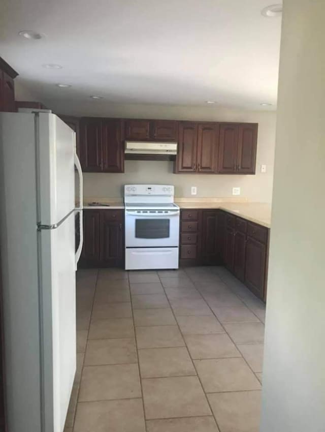 kitchen with white appliances and light tile patterned floors