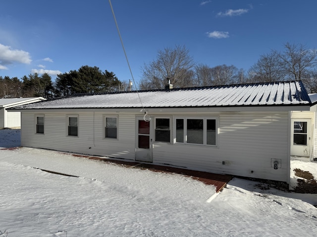 view of snow covered rear of property