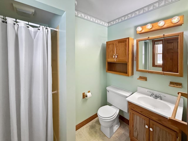 bathroom featuring toilet, vanity, and walk in shower