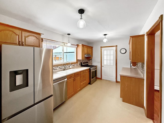 kitchen featuring a baseboard radiator, hanging light fixtures, appliances with stainless steel finishes, sink, and decorative backsplash